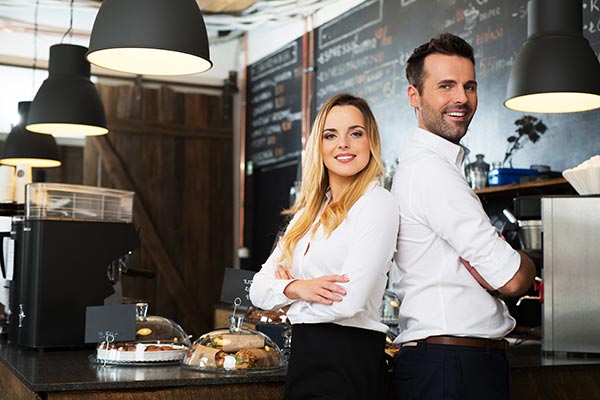 Young restaurant business owners with backs against each other