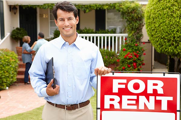 Man with For Rent sign and clipboard